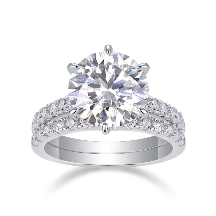 A bold 5-carat moissanite centerpiece ignites with icy fire, lifted on a sleek pavé band and paired with a perfectly matched diamond-lined alliance. A brilliant, modern duo made for unforgettable eleganc