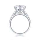 A bold 5-carat moissanite centerpiece ignites with icy fire, lifted on a sleek pavé band and paired with a perfectly matched diamond-lined alliance. A brilliant, modern duo made for unforgettable eleganc