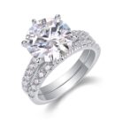 A bold 5-carat moissanite centerpiece ignites with icy fire, lifted on a sleek pavé band and paired with a perfectly matched diamond-lined alliance. A brilliant, modern duo made for unforgettable eleganc