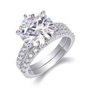 A bold 5-carat moissanite centerpiece ignites with icy fire, lifted on a sleek pavé band and paired with a perfectly matched diamond-lined alliance. A brilliant, modern duo made for unforgettable eleganc