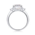 A breathtaking 5-carat emerald-cut moissanite framed by twin round stones, set on a sleek polished band for a crisp, high-clarity sparkle. Bold, refined, and timeless — a statement piece made to captivate